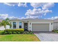 Charming single-story home with a well-manicured lawn, paver driveway, and an attached two-car garage at 6121 Blue Pond Way, St Cloud, FL 34771
