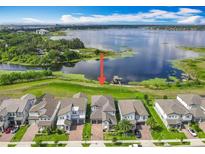 Beautiful waterfront property showcasing lush green lawns and lake access with a private dock at 7398 Alpine Butterfly Ln, Orlando, FL 32819