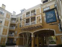 Exterior shot of a multi-story tan building with balconies and covered parking at Park North at Cheney Place at 860 N Orange Ave # 428, Orlando, FL 32801