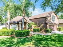 Charming two-story home features manicured landscaping, a two-car garage, and mature palm trees at 1007 Golf View Estates Dr, Orange City, FL 32763