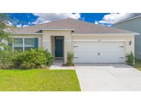 Charming single-story home with a well-manicured lawn and an attached two-car garage at 1312 Sugarwood St, Davenport, FL 33837