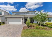 Charming two-story home with a brick driveway, well-manicured lawn and stone veneer details at 13330 Panama Beach Ct, Orlando, FL 32827