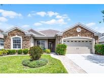 Charming single-story home with stone accents, well-manicured landscaping, and a two-car garage at 212 Tavestock Loop, Winter Springs, FL 32708