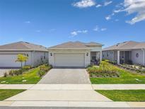 Charming single-story home boasts a two-car garage, complemented by a paver driveway and lush landscaping at 2766 Purple Meadow Ct, Minneola, FL 34715