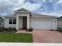 Charming single-story home with a brick driveway, manicured lawn, and two-car garage at 3450 Mclain Preserve Pt, Sanford, FL 32771