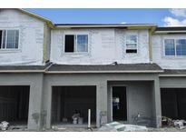 Unfinished townhouse exterior featuring garage and windows at 5099 Prairie Preserve Run, St Cloud, FL 34772