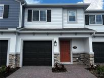 Charming townhome with brick driveway, stone accents, one-car garage, and inviting front entry at 5099 Prairie Preserve Run, St Cloud, FL 34772
