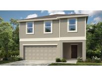 Charming two-story home featuring a neutral color scheme, inviting front entrance, and an attached two-car garage at 5109 Forget Me Not Ave, Lake Hamilton, FL 33851