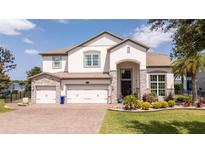 Charming two-story home with a well-manicured lawn, three-car garage, and beautiful stone accents at 16054 Johns Lake Overlook Dr, Winter Garden, FL 34787