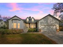 Charming single Gathering home featuring a landscaped front yard and welcoming entrance at dusk at 1667 Spring Loop Way, Winter Garden, FL 34787