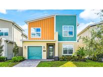 Modern two-story home featuring a colorful exterior, well-maintained landscaping, and an attached garage at 2791 Punctuation Pl, Kissimmee, FL 34746
