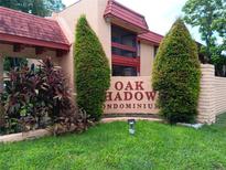 Inviting Oak Shadows Condominium signage with lush landscaping and well maintained grounds at 2810 N Powers Dr # 59, Orlando, FL 32818