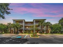 Attractive condominium building with tropical landscaping, ample parking, and private balconies for each unit at 304 Rum Run # 304, Davenport, FL 33897