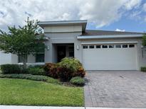 Charming single-story home with manicured lawn, brick driveway, and attached two-car garage at 3397 Sagebrush St, Harmony, FL 34773