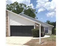 Traditional home exterior featuring a two-car garage, well-kept lawn, and attractive landscaping at 5284 Indian Laurel Ct, Orlando, FL 32808