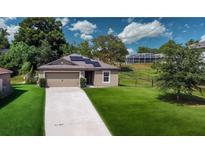 Charming one-story home features a well-maintained lawn, a two-car garage, and solar panels at 543 Nardello Dr, Deltona, FL 32725