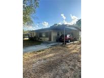 Single-story home featuring a carport, front yard, and neutral-toned exterior with a mix of sun and shade at 628 Cardinal St, Ocoee, FL 34761