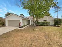 Charming single-story home with a stone accent facade, attached garage, and a well-maintained front yard at 9345 Buttonwood St, Orlando, FL 32825