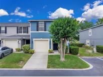 Charming blue townhome with a well-manicured lawn and attached one-car garage at 12928 Lexington Summit St, Orlando, FL 32828