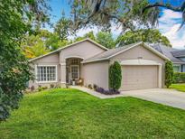 Charming single-story home featuring a well-manicured lawn and a two-car garage at 10105 Dean Point Pl, Orlando, FL 32825