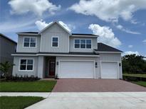 Two-story home showcasing a three-car garage, a red brick driveway, and a neatly manicured lawn at 1059 Gloryland Ct, Sanford, FL 32771