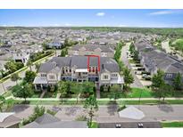 Beautiful three-story townhome with manicured landscaping and a charming front porch and balcony at 13865 Granger Ave, Orlando, FL 32827