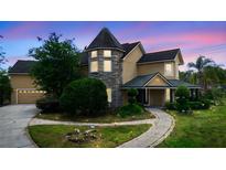 Beautiful home with stone tower, landscaped walkway, and attached two-car garage at 1415 Brumley Rd, Chuluota, FL 32766