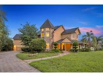 Stately exterior showcasing a unique turret design, lush landscaping, and inviting pathway to the front entrance at 1415 Brumley Rd, Chuluota, FL 32766
