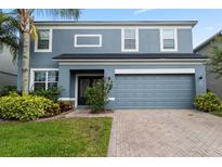 Charming two-story home featuring a well-maintained lawn, vibrant landscaping, and a two car garage at 15210 Montesino Dr, Orlando, FL 32828