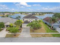 Stunning lakefront home featuring lush landscaping, a spacious driveway, and an attached two-car garage at 2803 Boating Blvd, Kissimmee, FL 34746