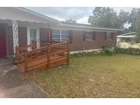 Charming single-story brick home with a wooden ramp leading to the front door at 404 E Kentucky Ave, Deland, FL 32724