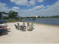 Enjoy lakefront living with a sandy beach area with chairs and a fire pit by the water at 4109 Fairview Vista Pt # 315, Orlando, FL 32804