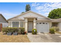 Charming single-story home featuring a well-maintained lawn, inviting entrance, and attached garage at 4561 Heritage Oak Dr, Orlando, FL 32808
