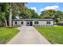 Charming single-story home featuring a well-maintained front yard and a long concrete driveway at 50 Community Dr, Debary, FL 32713