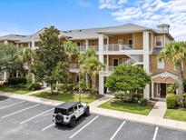 Beautiful condo building featuring multiple stories, balconies, lush landscaping, and convenient parking at 510 Rum Run # 33 510, Davenport, FL 33837