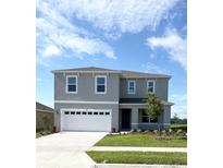 Two-story home with a gray facade, well-manicured lawn, and a two-car garage at 5168 Greenheart Ave, Mount Dora, FL 32757