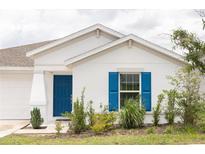 Charming single-story home features a blue front door and matching shutters, set against a white exterior at 707 Staffora St, Haines City, FL 33844