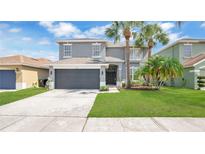 Charming two-story home featuring a gray exterior, well-manicured lawn, and a two-car garage at 726 Lake Biscayne Way, Orlando, FL 32824