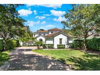 Beautiful two-story home with a well manicured lawn, lush landscaping, and brick paved driveway at 9743 Covent Garden Dr, Orlando, FL 32827