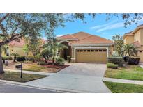 Charming single-story home boasting a tile roof, arched entryway, and well-manicured landscaping at 11556 Via Lucerna Cir, Windermere, FL 34786