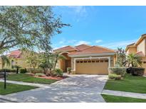Charming single-story home with a tile roof, brick driveway, and meticulously manicured landscaping at 11556 Via Lucerna Cir, Windermere, FL 34786