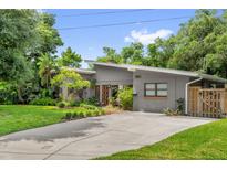 Charming single-story home featuring a well-manicured lawn, wood accents, and a stylish modern design at 1632 Oriole Ave, Orlando, FL 32803
