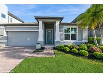 Charming home featuring a brick walkway leading to a covered entry and a well-manicured lawn with lush landscaping at 1757 Standing Rock Cir, Oakland, FL 34787
