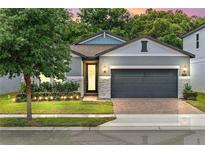 Charming single-Gathering home featuring a two-car garage, stone accents, and professionally landscaped front yard at 2159 Marsh Sedge Ln, Winter Park, FL 32792