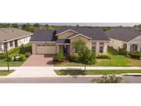 Beautiful one-story home with a well-manicured lawn, brick driveway, and a two-car garage at 2604 Meadowedge Loop, St Cloud, FL 34772