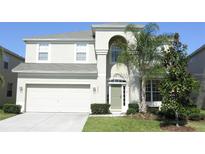 Charming two-story home with lush green lawn, attached two-car garage, and covered entryway at 2605 Daulby St, Kissimmee, FL 34747
