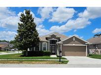 Charming single-story home with a well-manicured lawn and attached two-car garage at 2752 Bellewater Pl, Oviedo, FL 32765