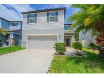 Two-story home featuring a two-car garage, neutral paint, and well-maintained landscaping at 2783 Red Horse Dr, Kissimmee, FL 34744