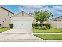 Charming home showcasing a two-car garage, well-manicured lawn, and decorative landscaping adding curb appeal at 3945 Angola Ln, Sanford, FL 32771
