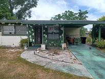 Modest single story home with covered parking and green trim on an overcast day at 442 Fanfair Ave, Orlando, FL 32811